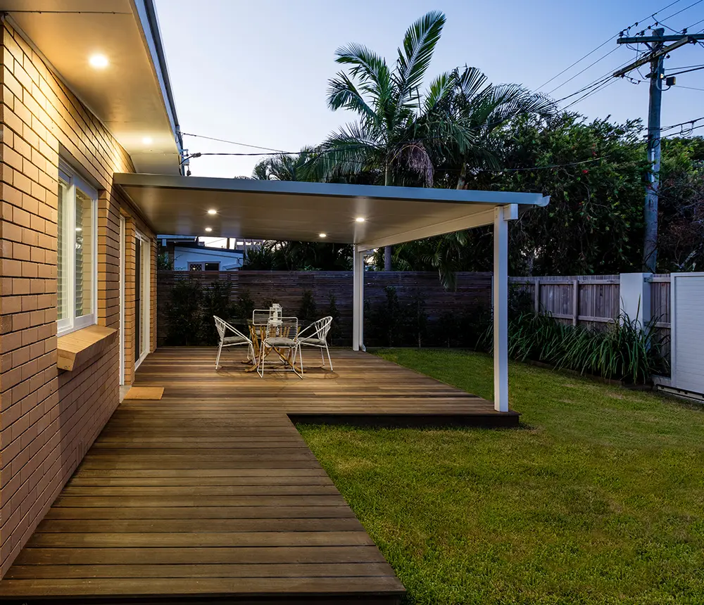 ground-level decking with a pergola and outdoor furniture