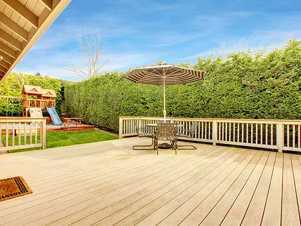 A composite deck with a tall bush fence