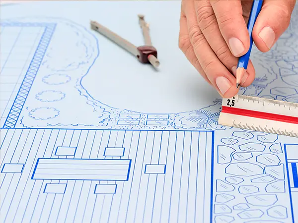 a man measuring on a landscaping drawing