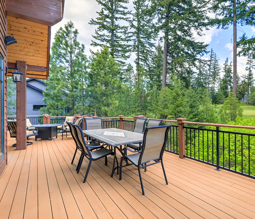 a wood deck with metal railings and outdoor furniture