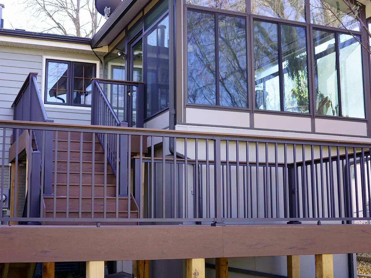 A beautiful deck on two levels with aluminum railings and a screened-in porch