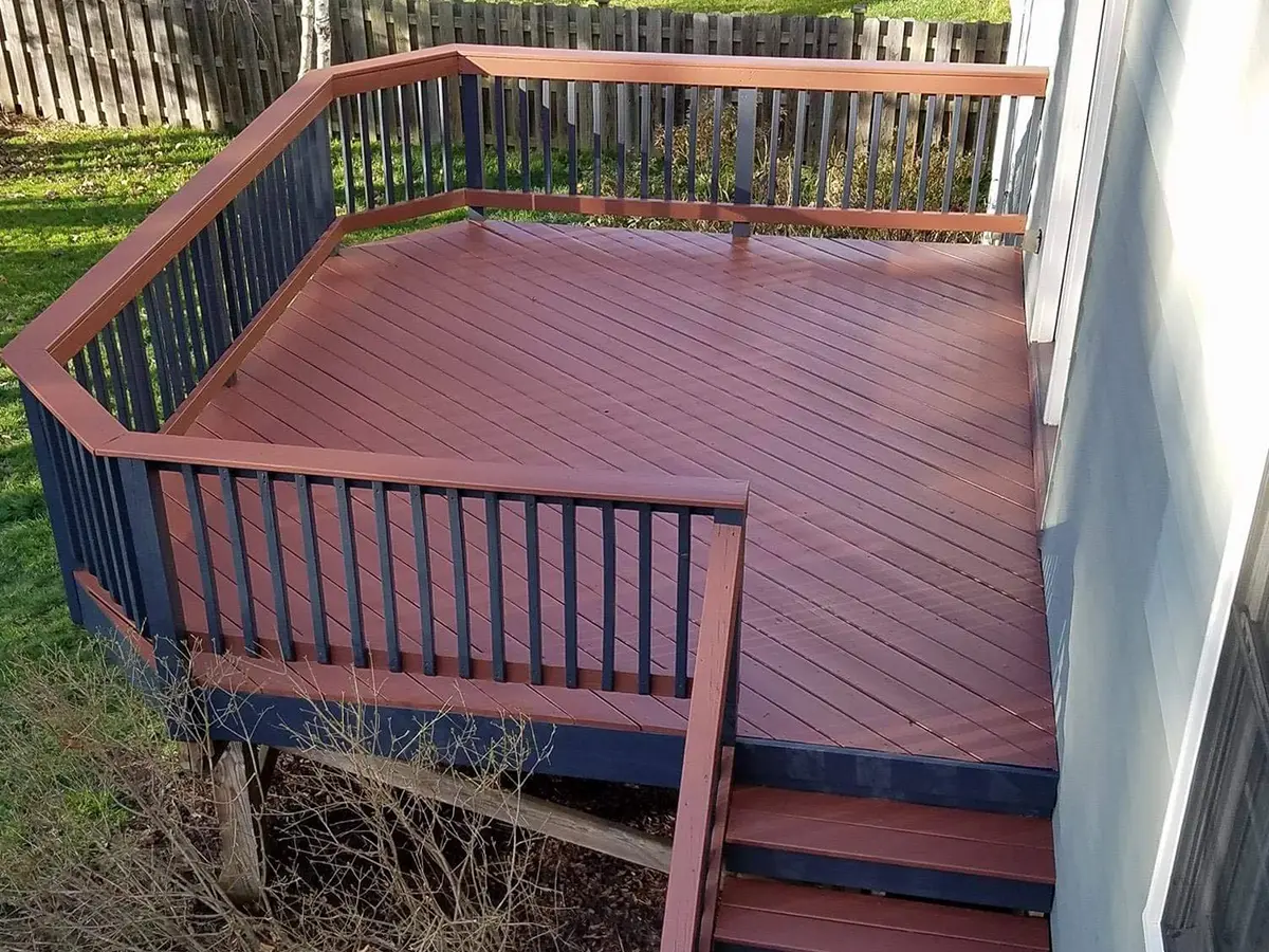 A wood deck with balustrade painted in red and metal railings