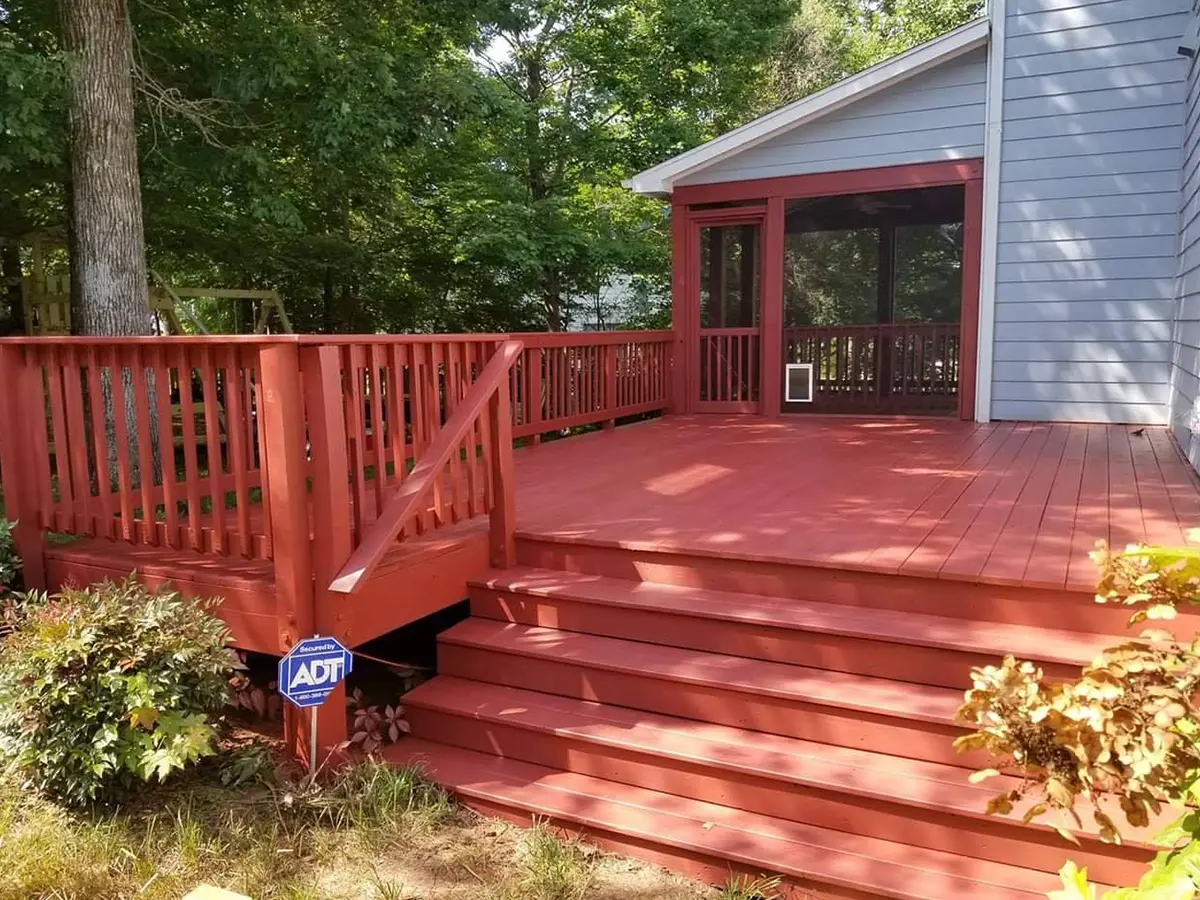 A wood deck with railings painted in red