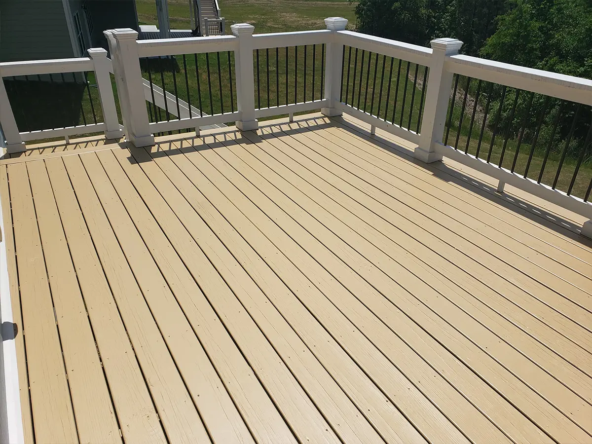 A wood deck with white balustrade and black, metal railings
