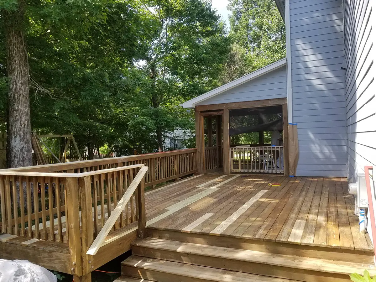 A wood deck with reinforced railings and some floorboards replaced