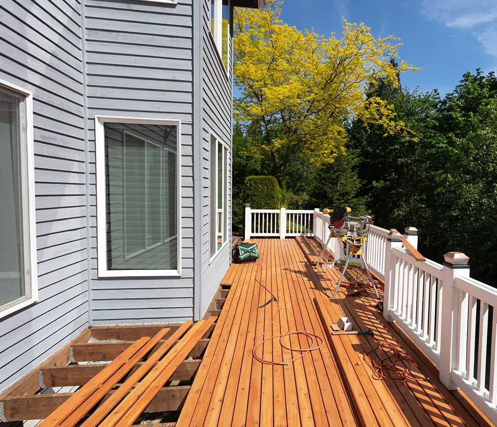 A cedar fence with a white metal railing being repaired