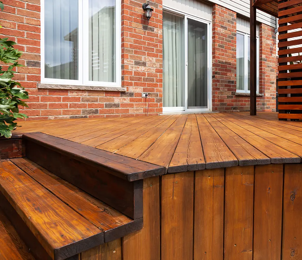 Wood decking attached to a house with brick siding