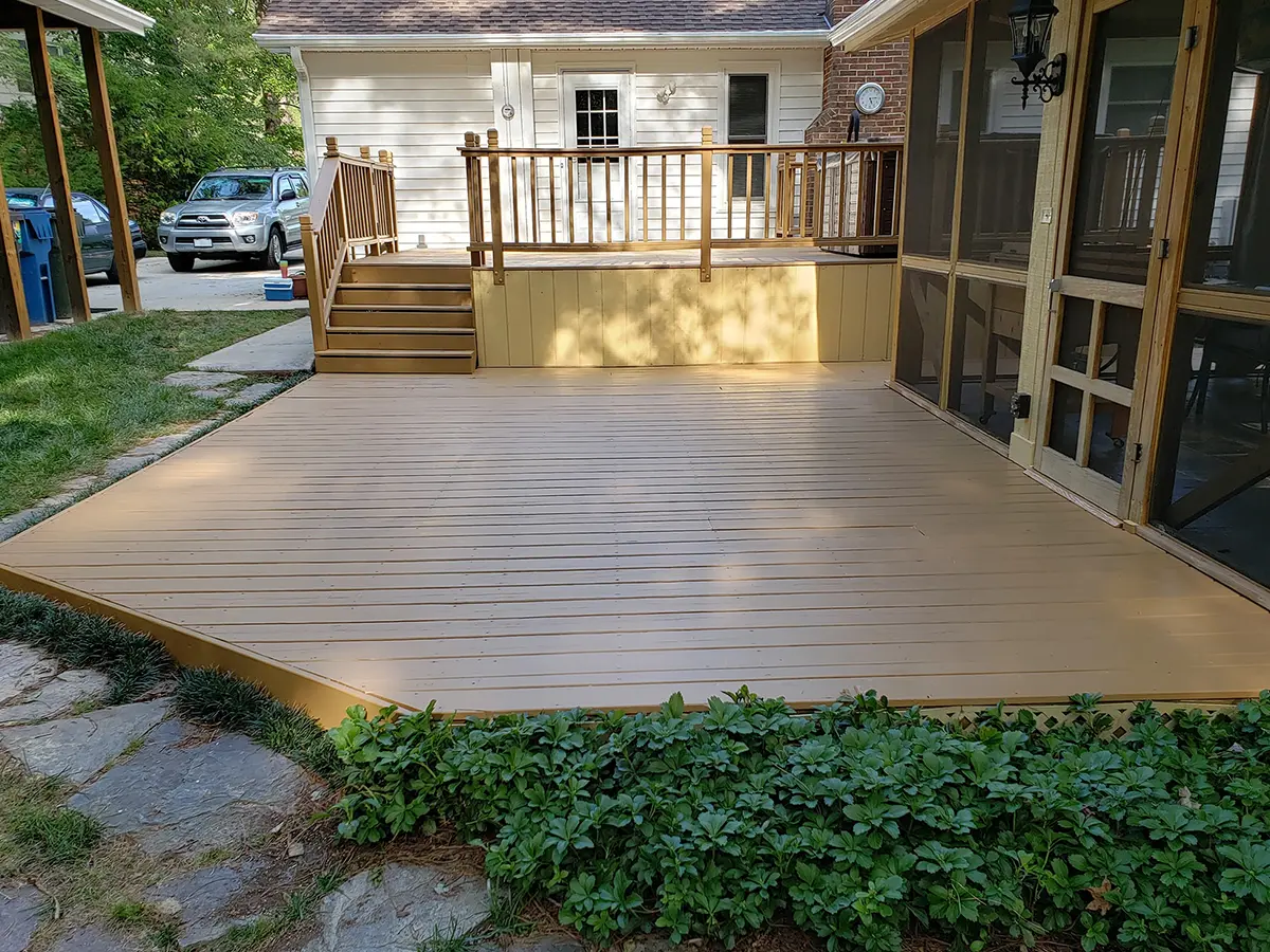 A beige composite deck on ground level, coupled with another one that's elevated from the ground