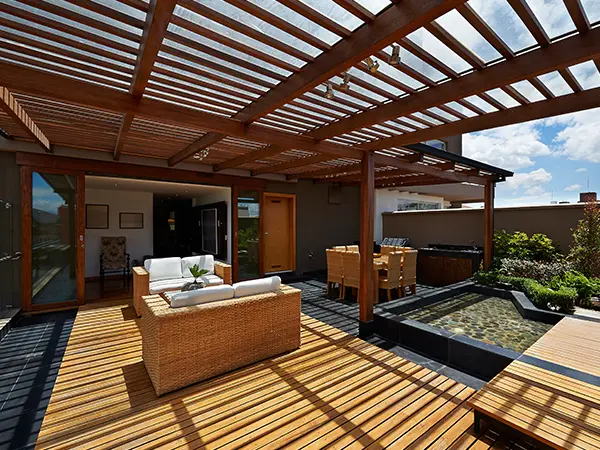 a covered deck with real hardwood and a small pond