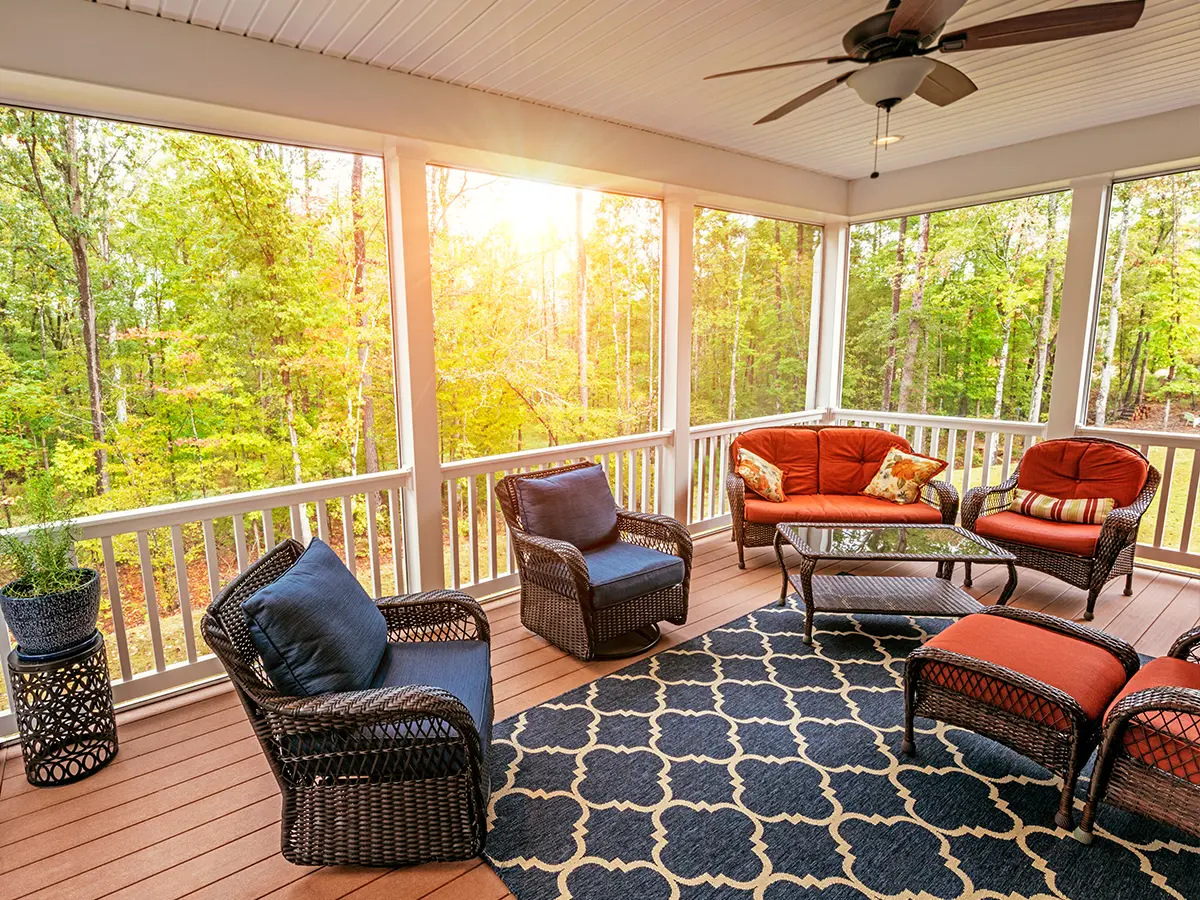 A beautiful screened-in porch with composite decking and outdoor furniture