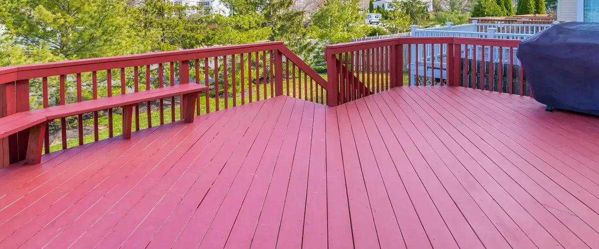 A spacious backyard deck featuring a smooth, newly painted surface ready for outdoor furniture and hosting.